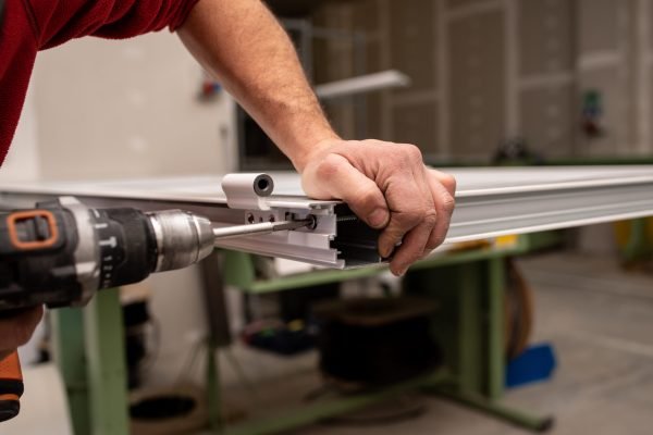 Male with a red shirt making a window with industrial tools A male with a red shirt making a window with industrial tools